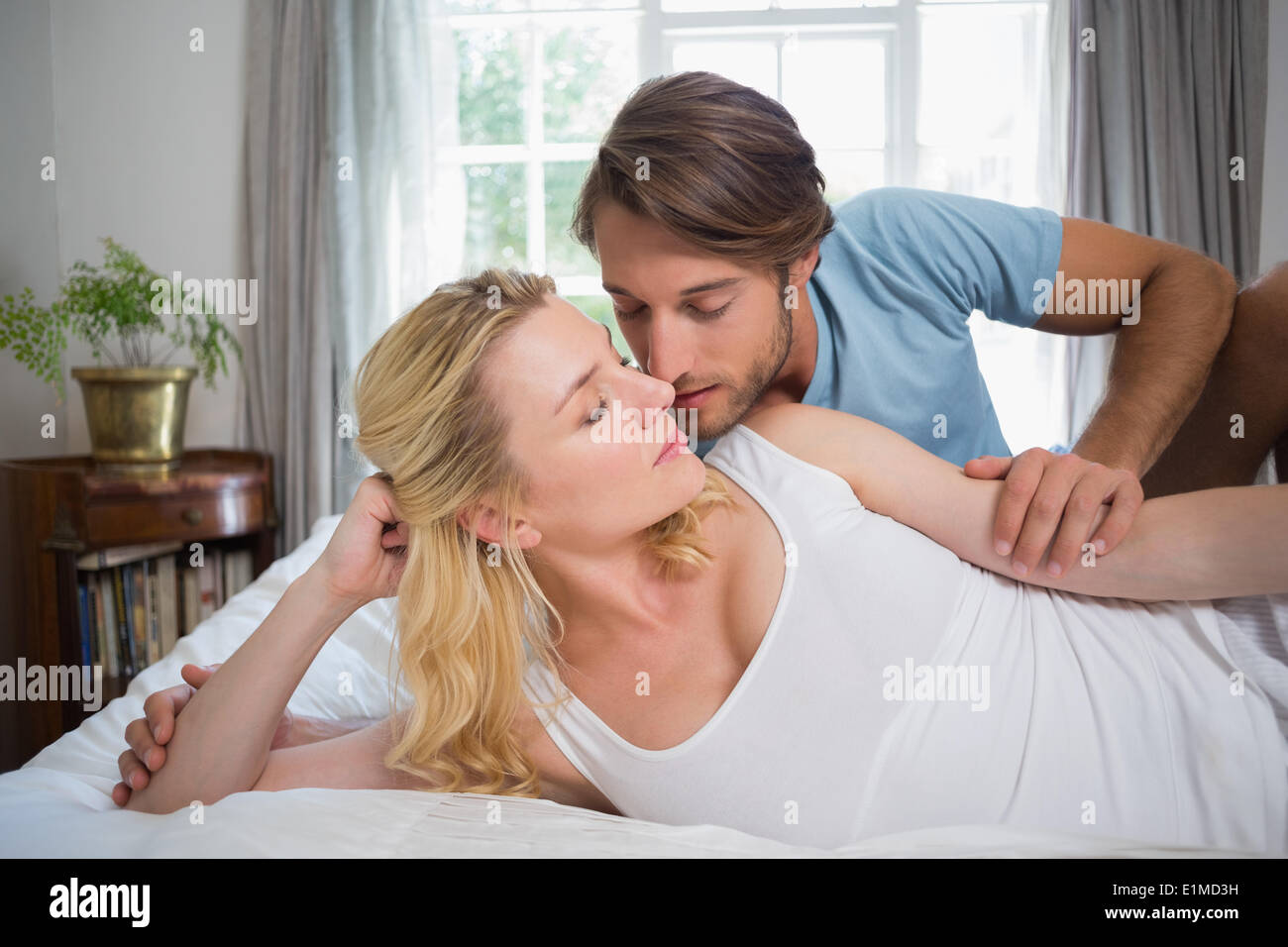 Cute couple relaxing on bed about to kiss Stock Photo