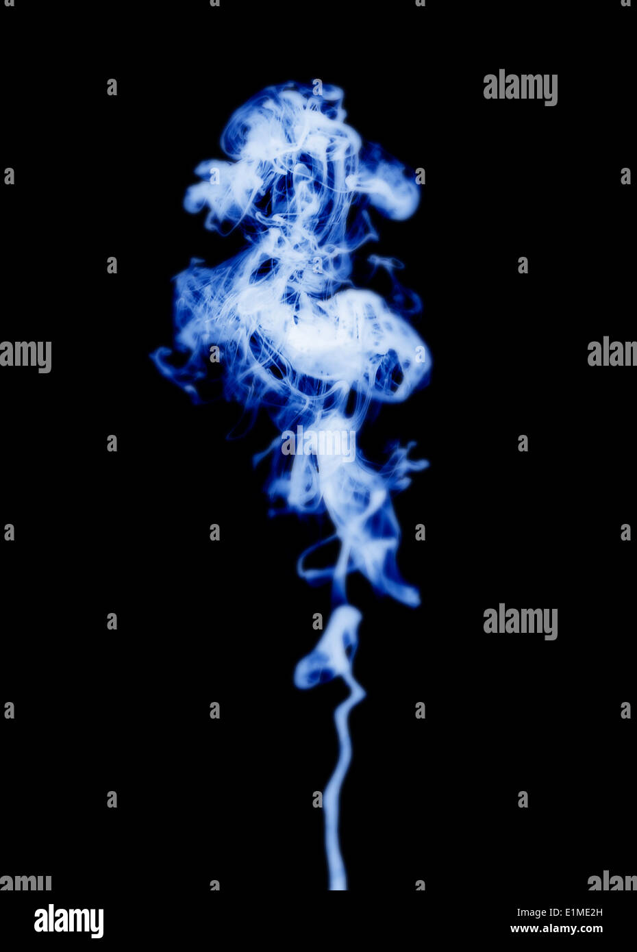 Looking like blue or purple colored smoke on a black background. Stock Photo