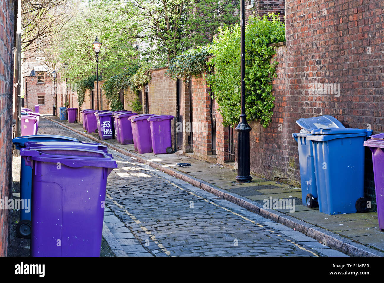 Wheelie bins lined up on narrow cobblestoned road Stock Photo Alamy