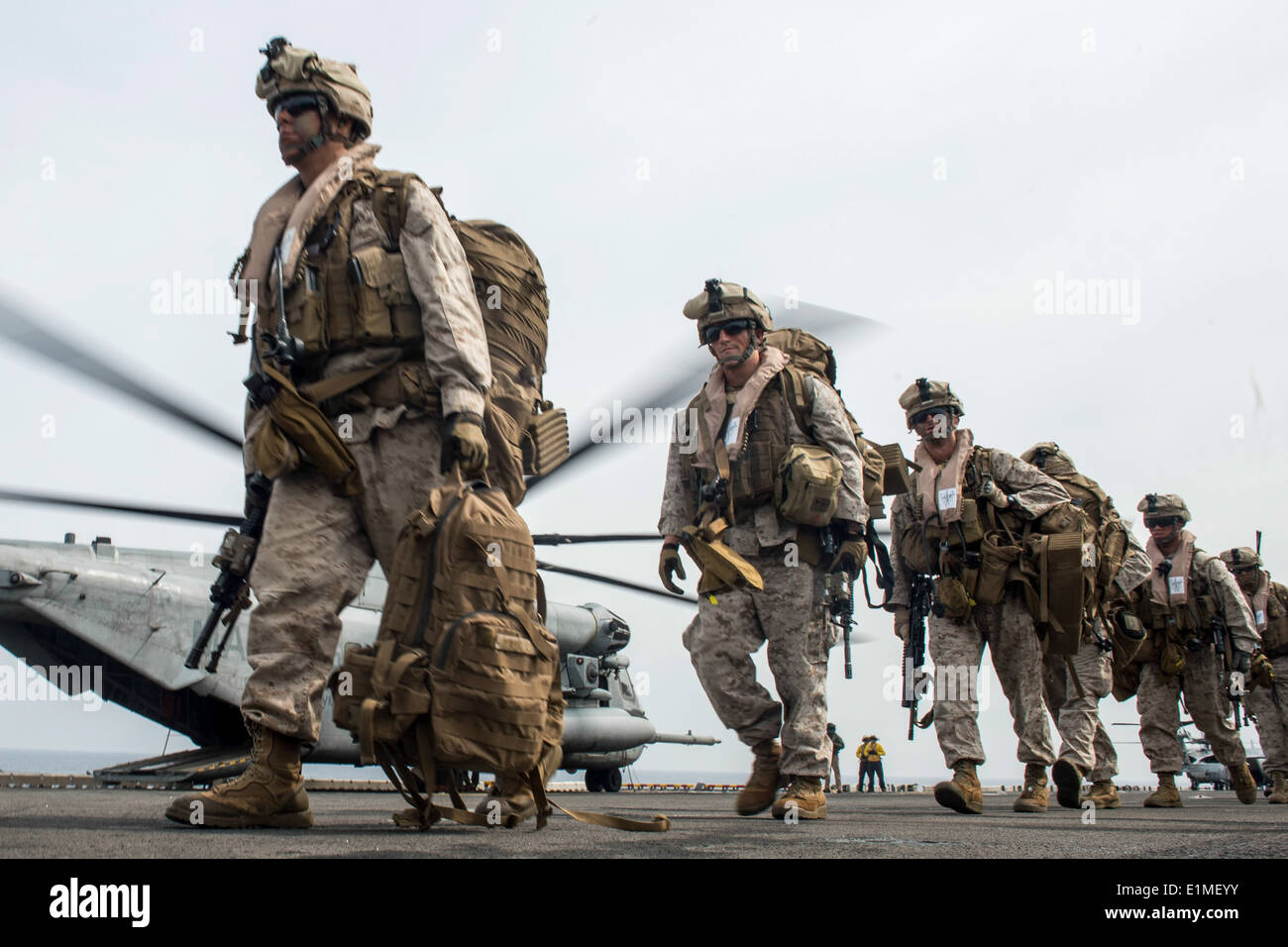 U.S. Marines assigned to the 13th Marine Expeditionary Unit prepare to board a CH-53E Super Stallion helicopter on the amphibio Stock Photo
