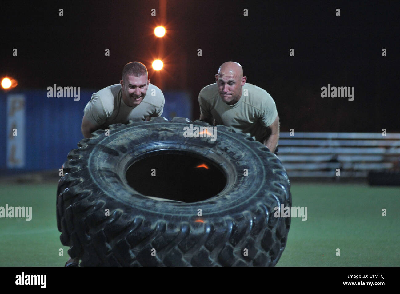 U.S. Service members flip a tire during the Memorial Mash in honor of U.S. Air Force Chief Master Sgt. Nick McCaskill at Camp L Stock Photo
