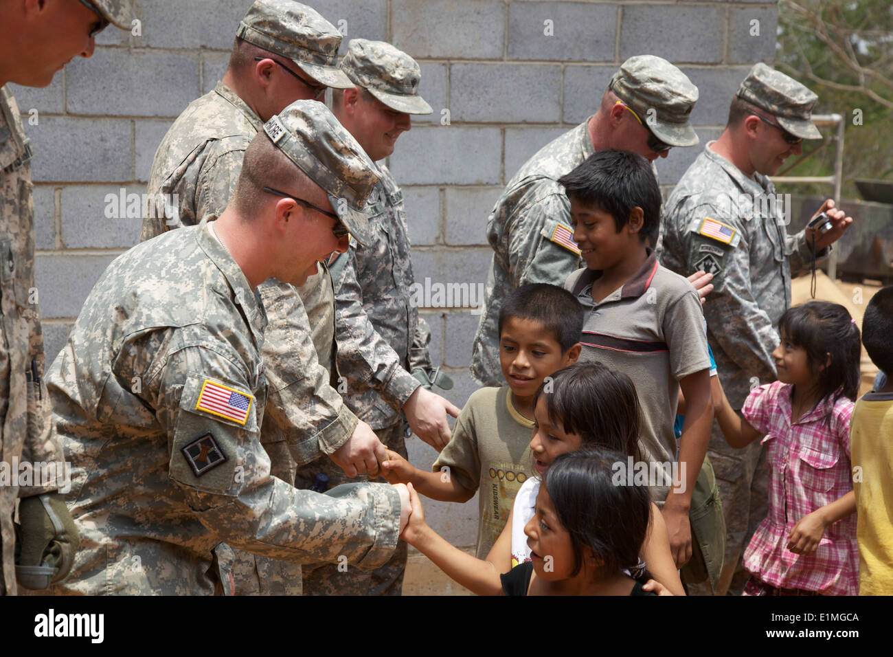 U.S. Soldiers assigned to the 1430th Engineer Company, Michigan Army National Guard shake hands with Guatemalan school children Stock Photo
