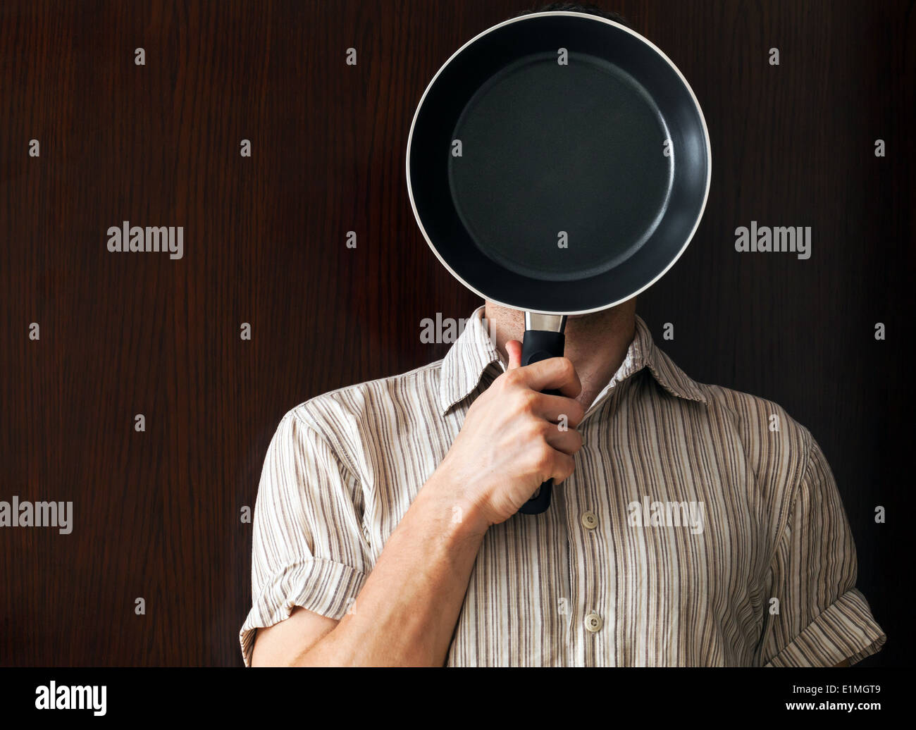 Young man portrait behind black frying pan Stock Photo