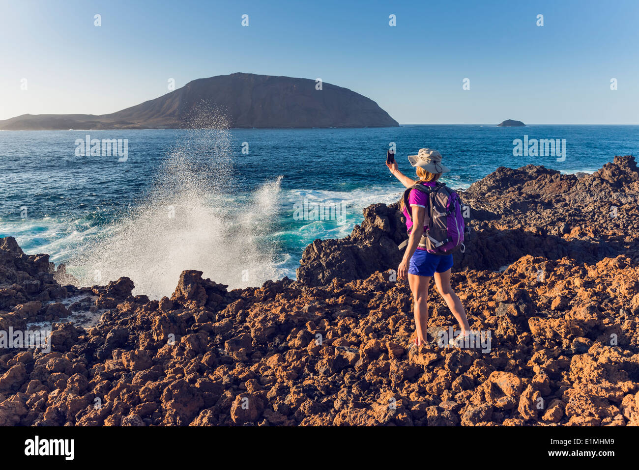 Woman taking a photo at La Graciosa Island, Lanzarote, Canary Islands, Spain. Stock Photo