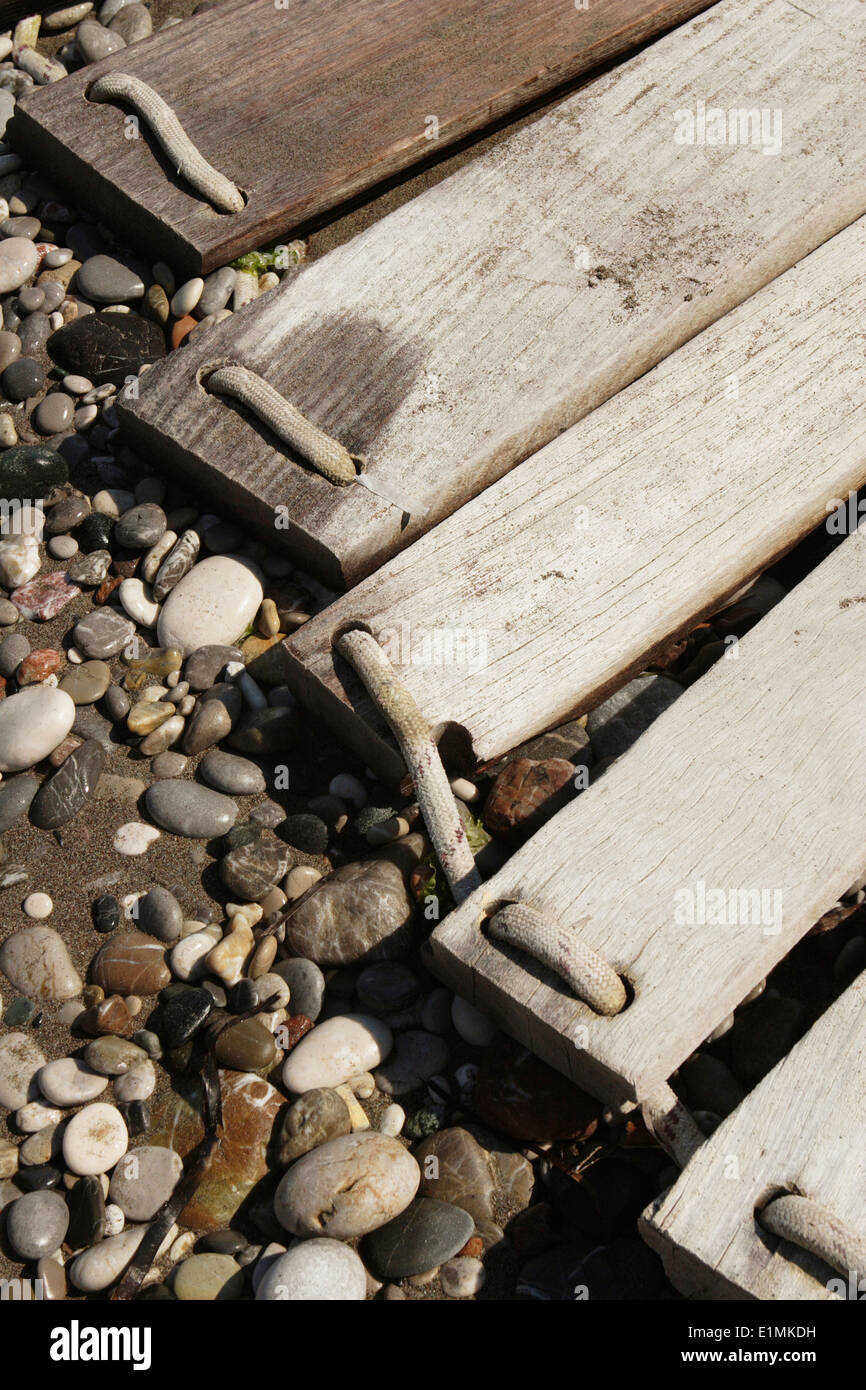 Detail wood plank on pebbles, Rhodes Island, Ixia Rhodes, East Coast, Greece Stock Photo