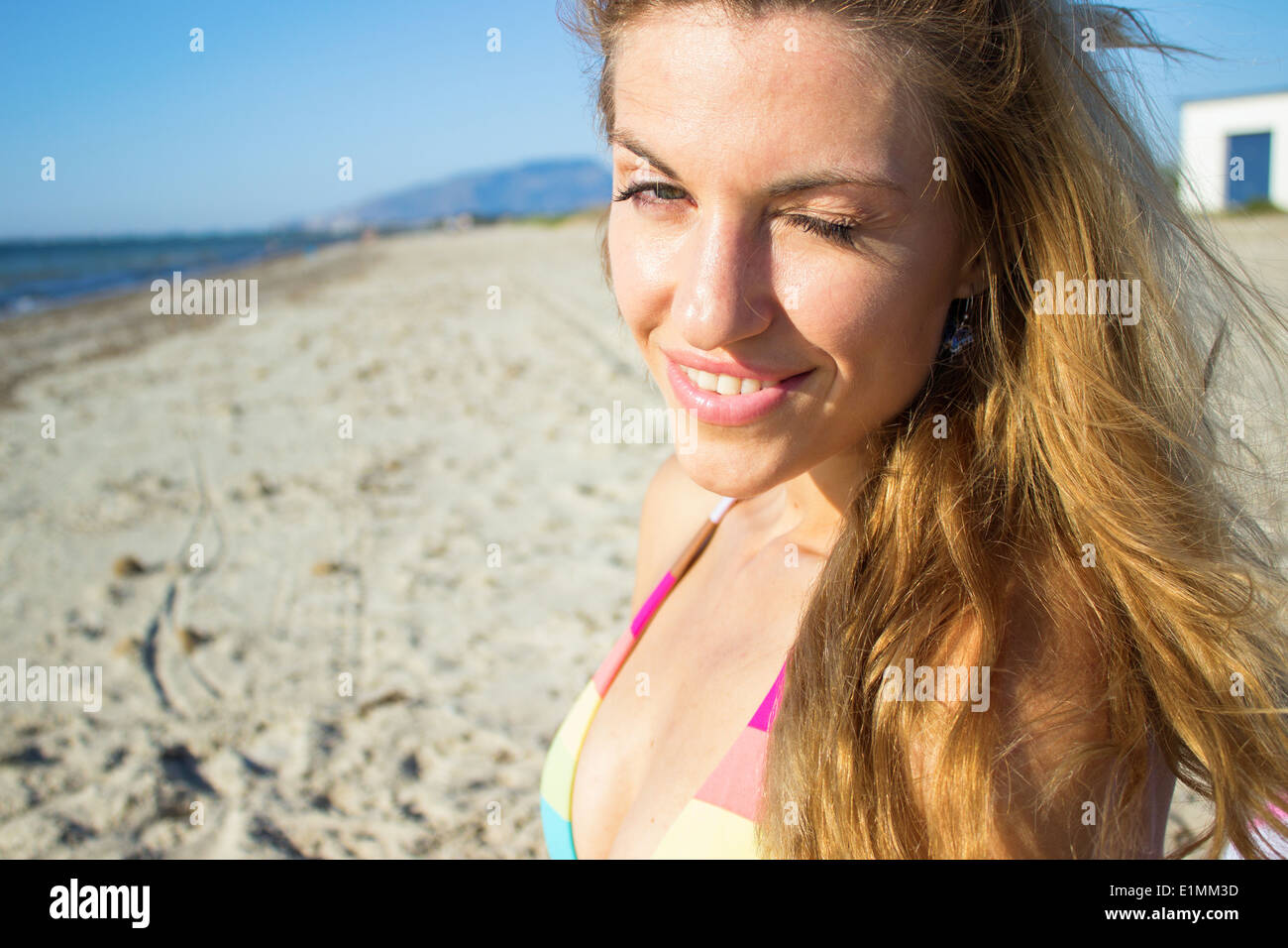 young woman face wink bikini portrait beach sea 'looking at camera' closeup beautiful blond hair blonde 'long hair' Stock Photo