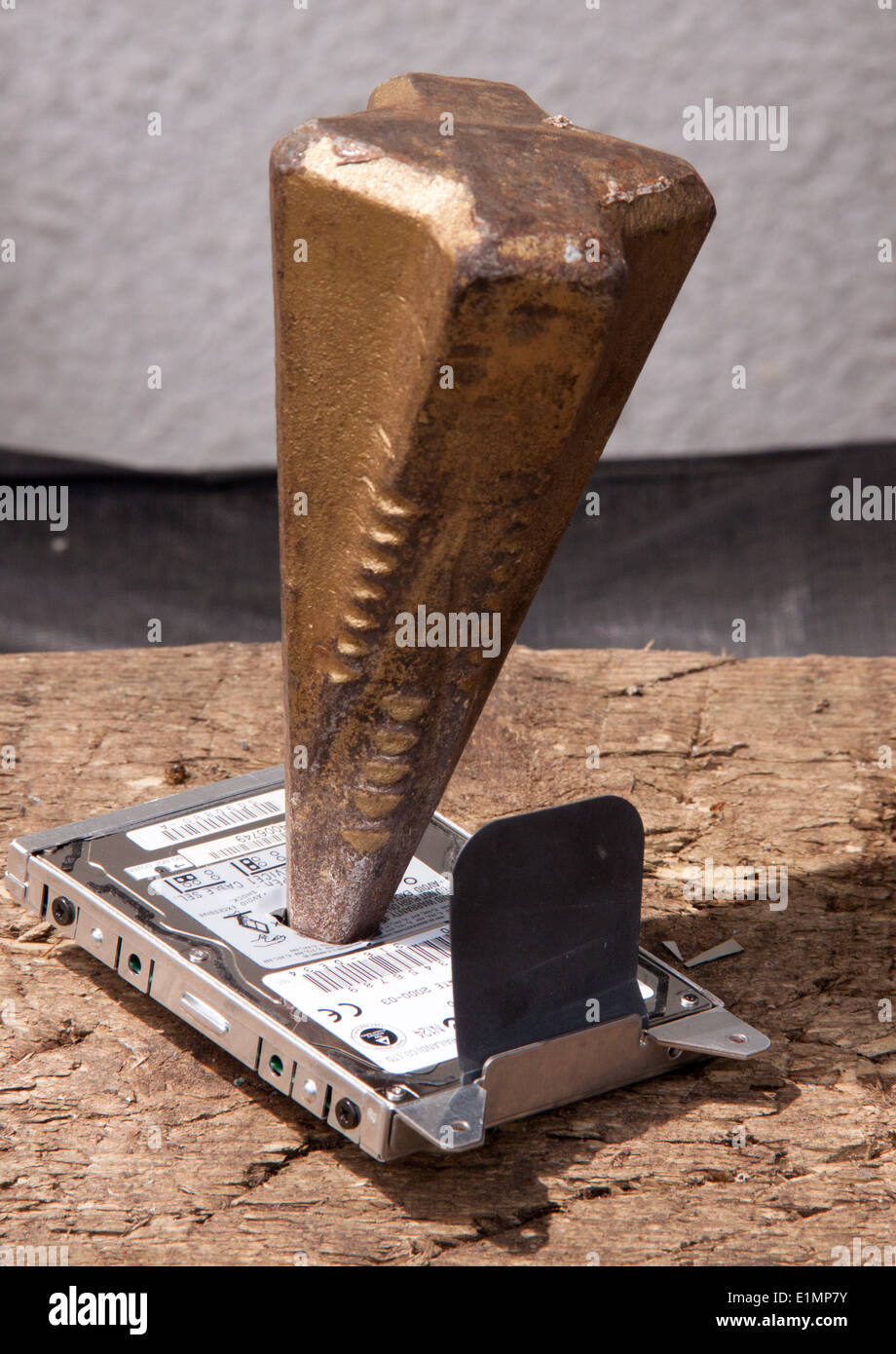 Destroying a computer hard drive by driving a log splitter through it. Stock Photo
