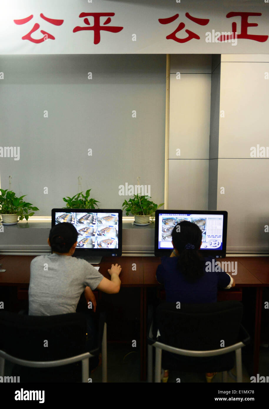 Shenyang, China's Liaoning Province. 7th June, 2014. Staff members scrutinize exam sites through monitors at an office of national college entrance exam in Shenyang, capital of northeast China's Liaoning Province, June 7, 2014. The exam, known as the 'gaokao', began on Saturday. A total of 9.39 million people have registered for the exam this year to vie for 6.98 million vacancies in universities and colleges. © Yang Qing/Xinhua/Alamy Live News Stock Photo