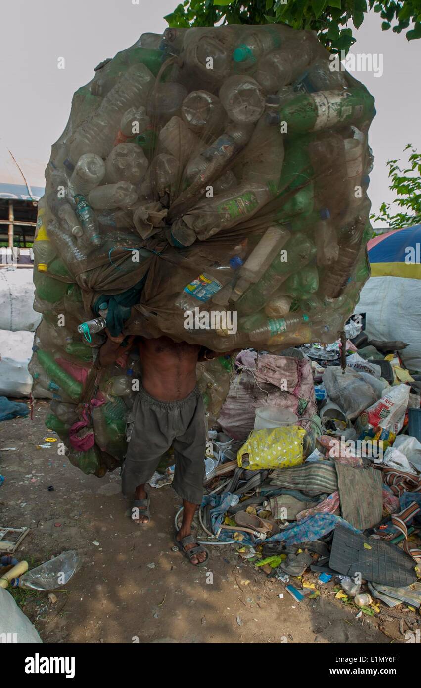 Calcutta, Indian state West Bengal. 6th June, 2014. An Indian rag-picker carries a sack of used plastic bottles collected from garbage near a dumping ground in Calcutta, capital of eastern Indian state West Bengal, June 6, 2014. According to National Physical Laboratory report 2013, garbage pressure in Calcutta of 16.5 tonnes per square kilometer, is the highest in the country. © Tumpa Mondal/Xinhua/Alamy Live News Stock Photo