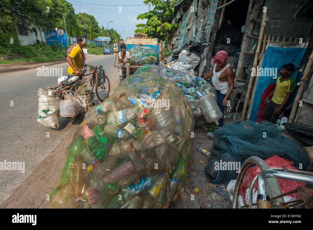 Calcutta, Indian state West Bengal. 6th June, 2014. Indian rag-pickers carry sacks of used plastic bottles collected from garbage near a dumping ground in Calcutta, capital of eastern Indian state West Bengal, June 6, 2014. According to National Physical Laboratory report 2013, garbage pressure in Calcutta of 16.5 tonnes per square kilometer, is the highest in the country. © Tumpa Mondal/Xinhua/Alamy Live News Stock Photo