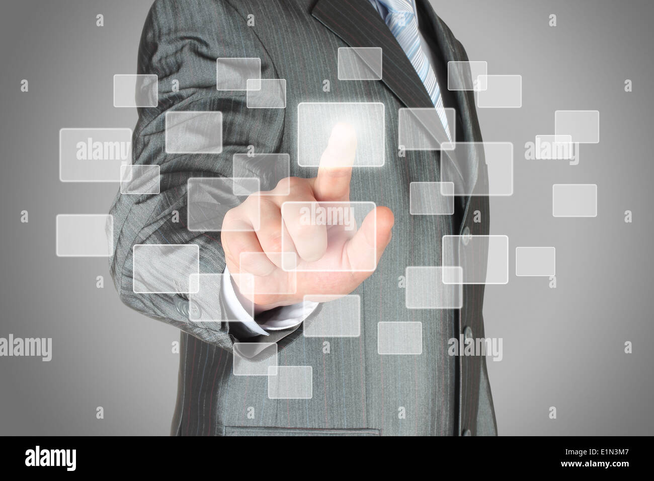 Businessman with hand using virtual inteface on grey background Stock Photo