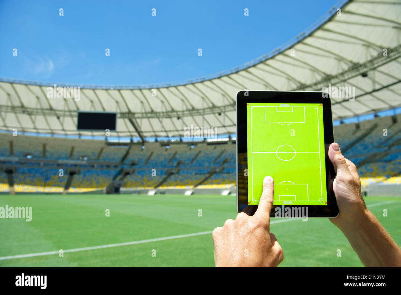 Hands planning match on blank tactics board in front of soccer field at football stadium Rio de Janeiro Brazil Stock Photo