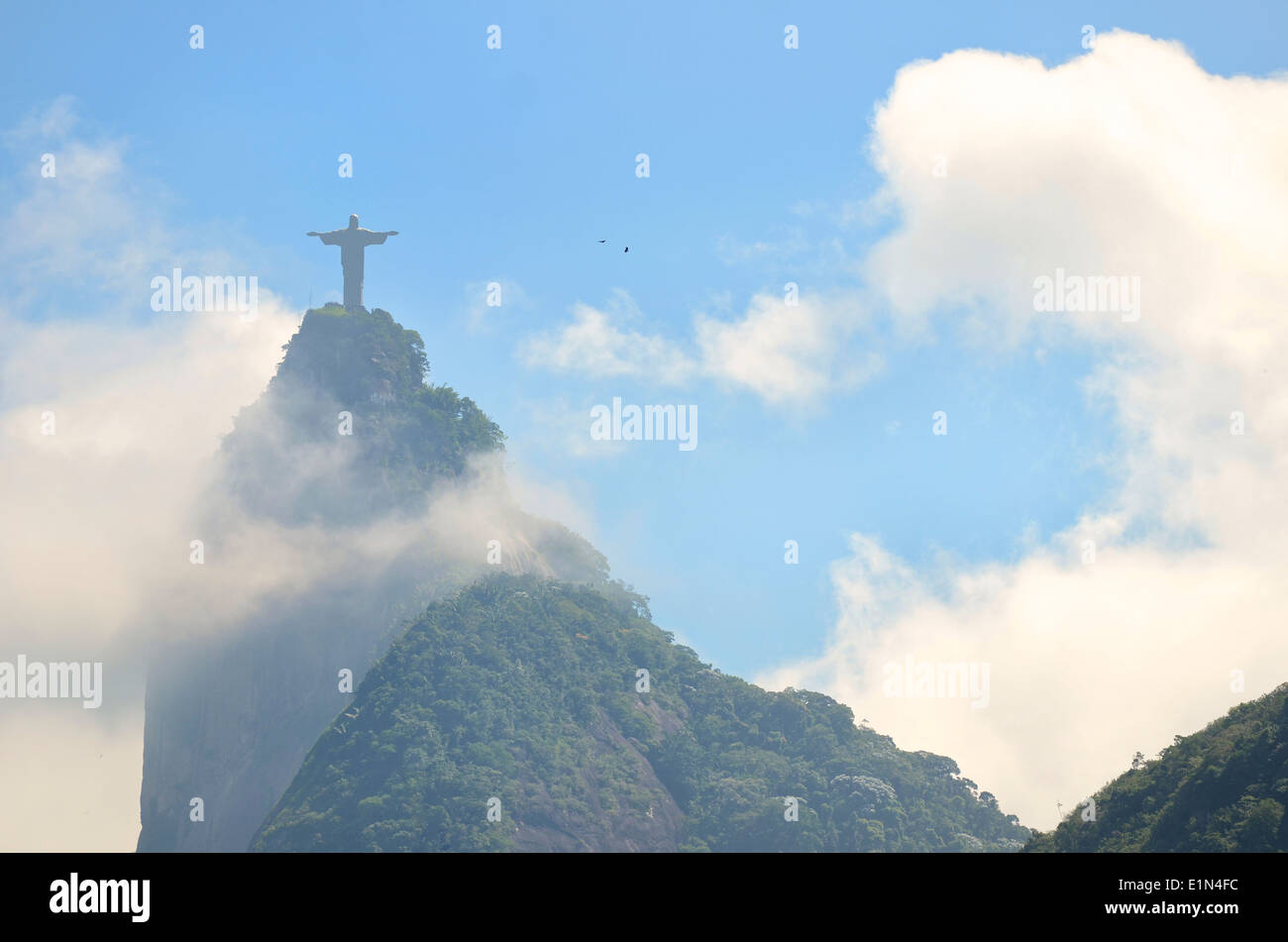 Corcovado mountain Christ the Redeemer standing above swirling mist clouds and jungle in Rio de Janeiro Brazil Stock Photo