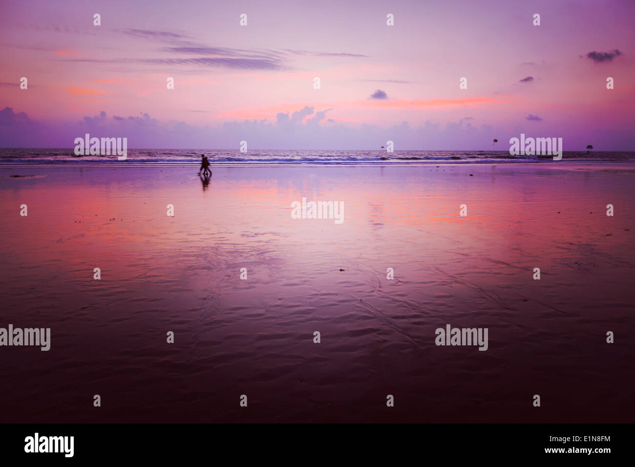 Couple walking on beach on romantic sunset. Baga beach. Goa, India Stock Photo