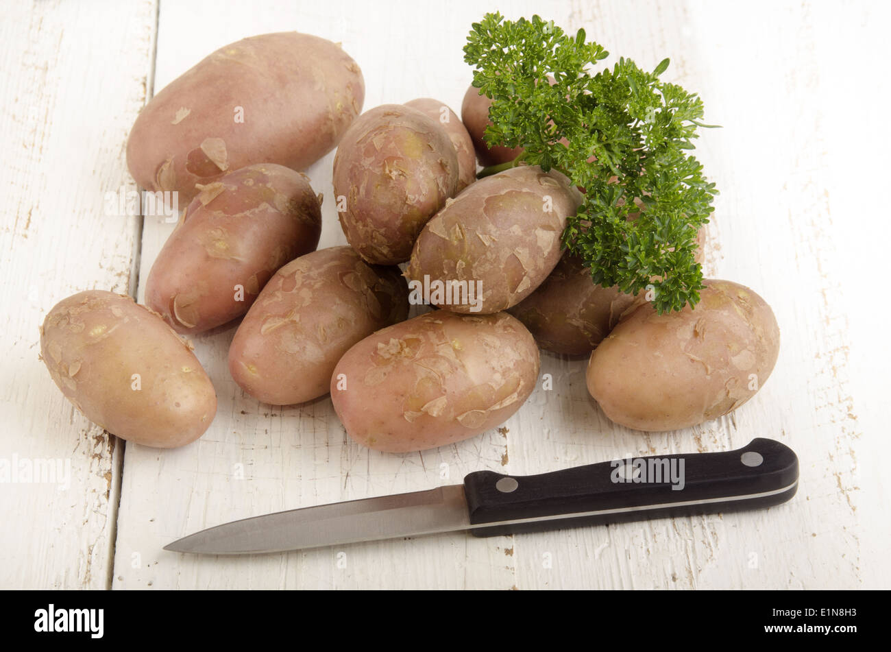 https://c8.alamy.com/comp/E1N8H3/potato-parsley-and-kitchen-knife-on-white-wood-E1N8H3.jpg