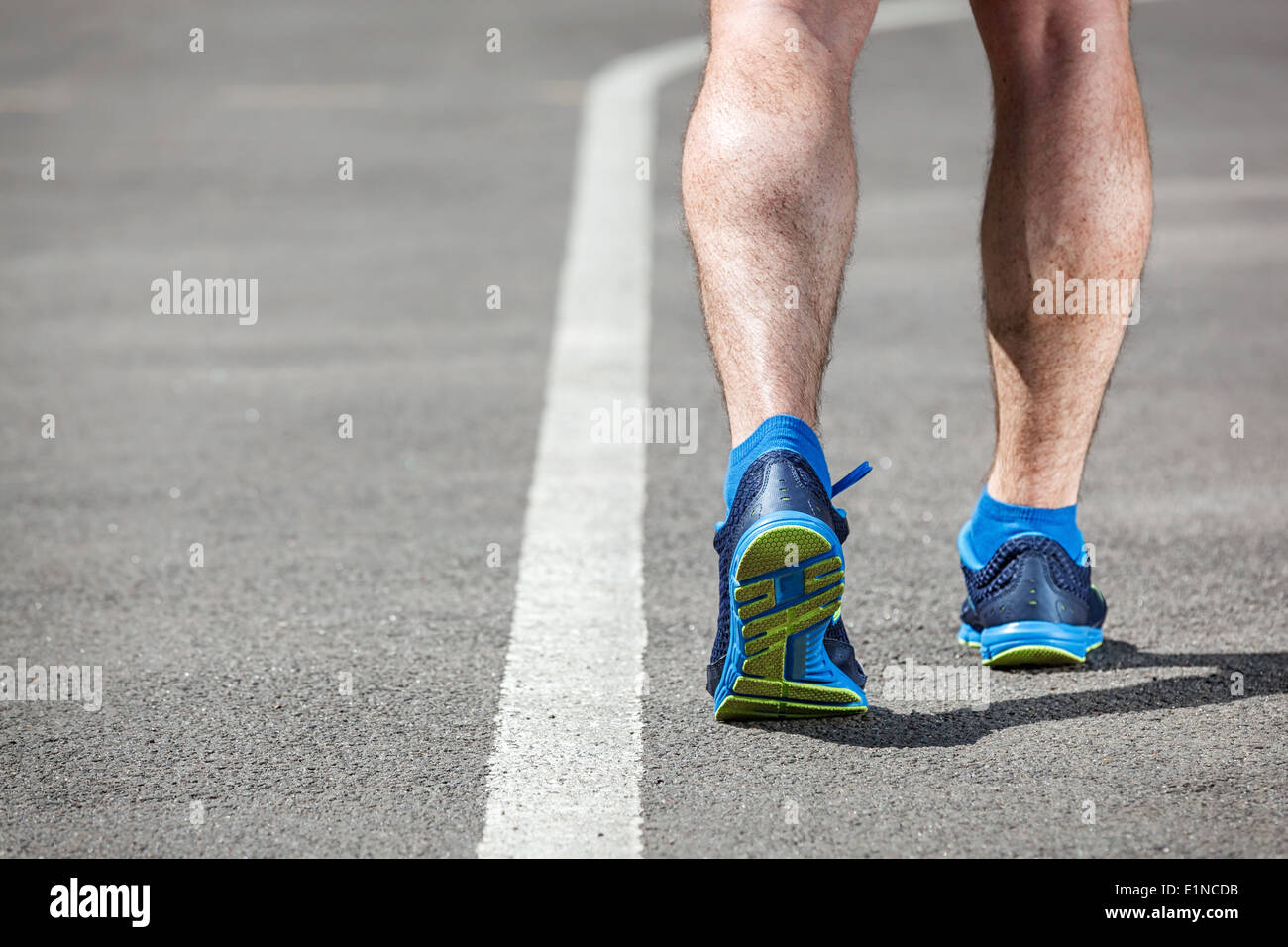 Runner feet running on stadium closeup on shoe - back view. Stock Photo