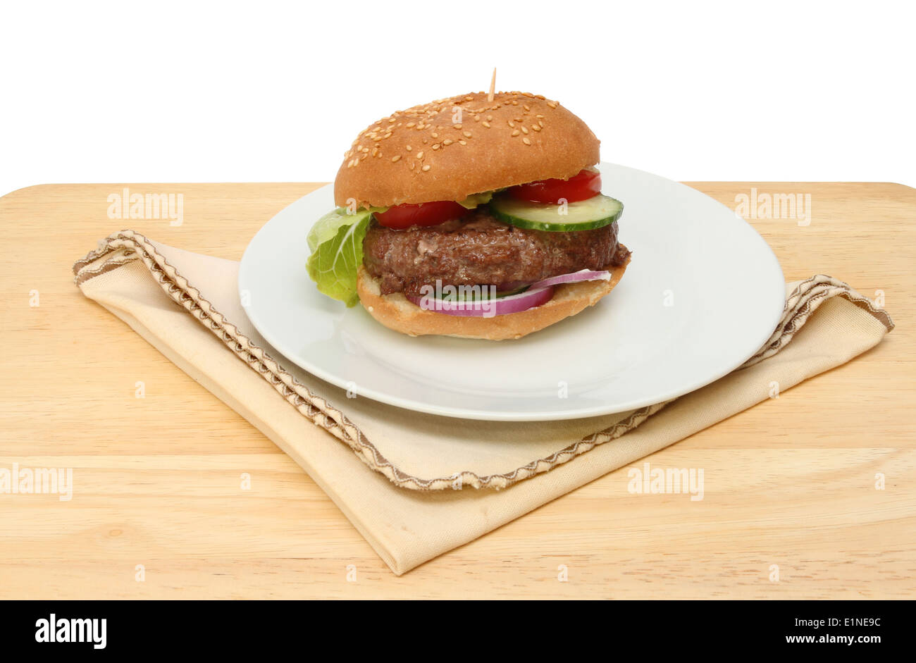 Beef burger on a plate with a serviette on a wooden table Stock Photo