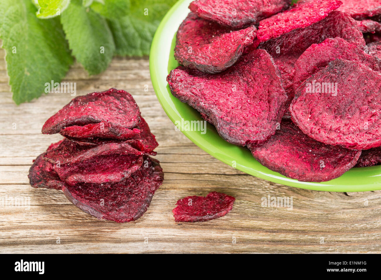 red beet chips in a green bowl - a healthy vegetable snack Stock Photo
