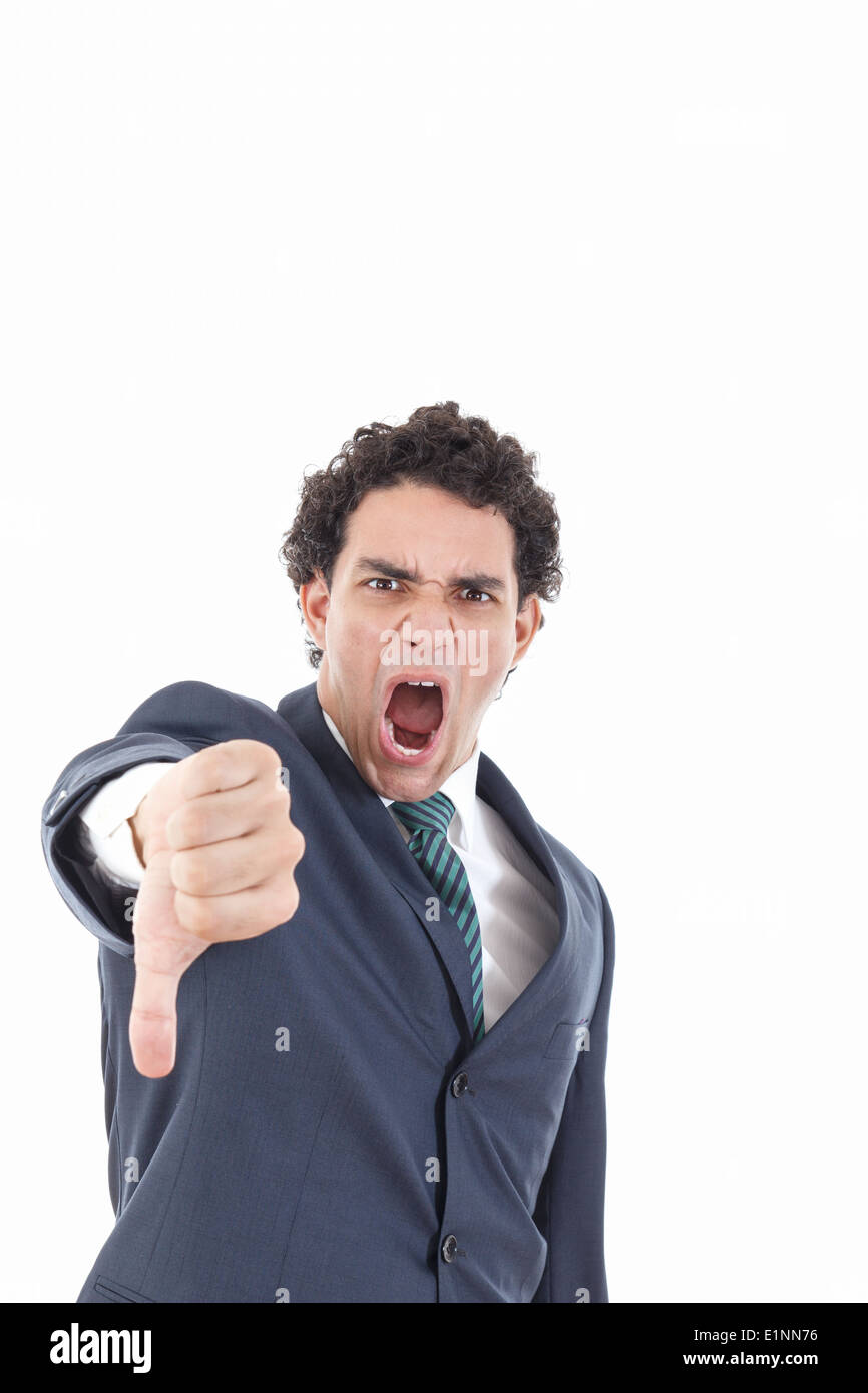 Disappointed young businessman showing thumb down sign yelling isolated on white, angry business man with disagreement gesture Stock Photo