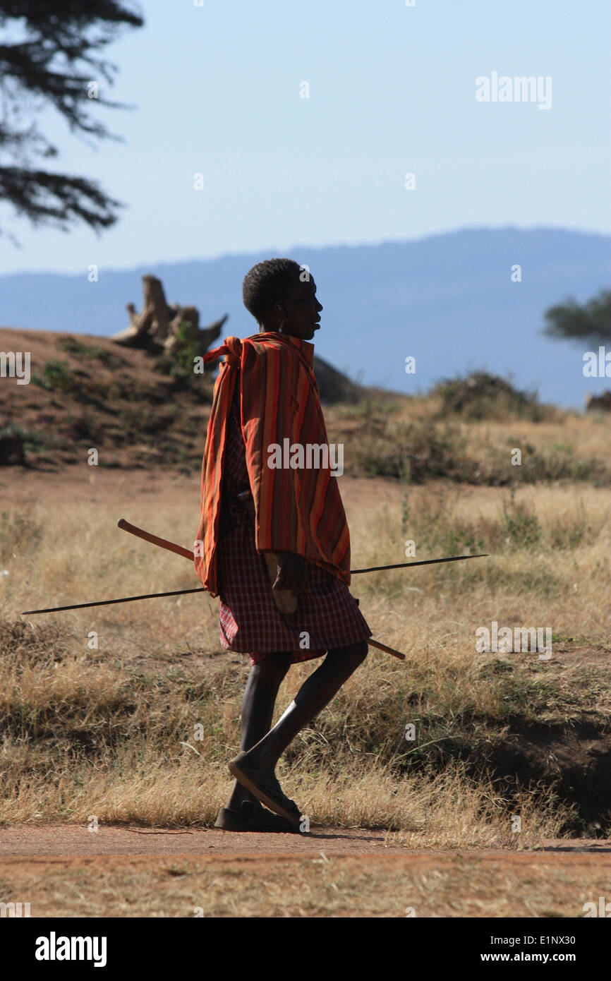 Maasai boy walking in wild Africa for hunting Stock Photo