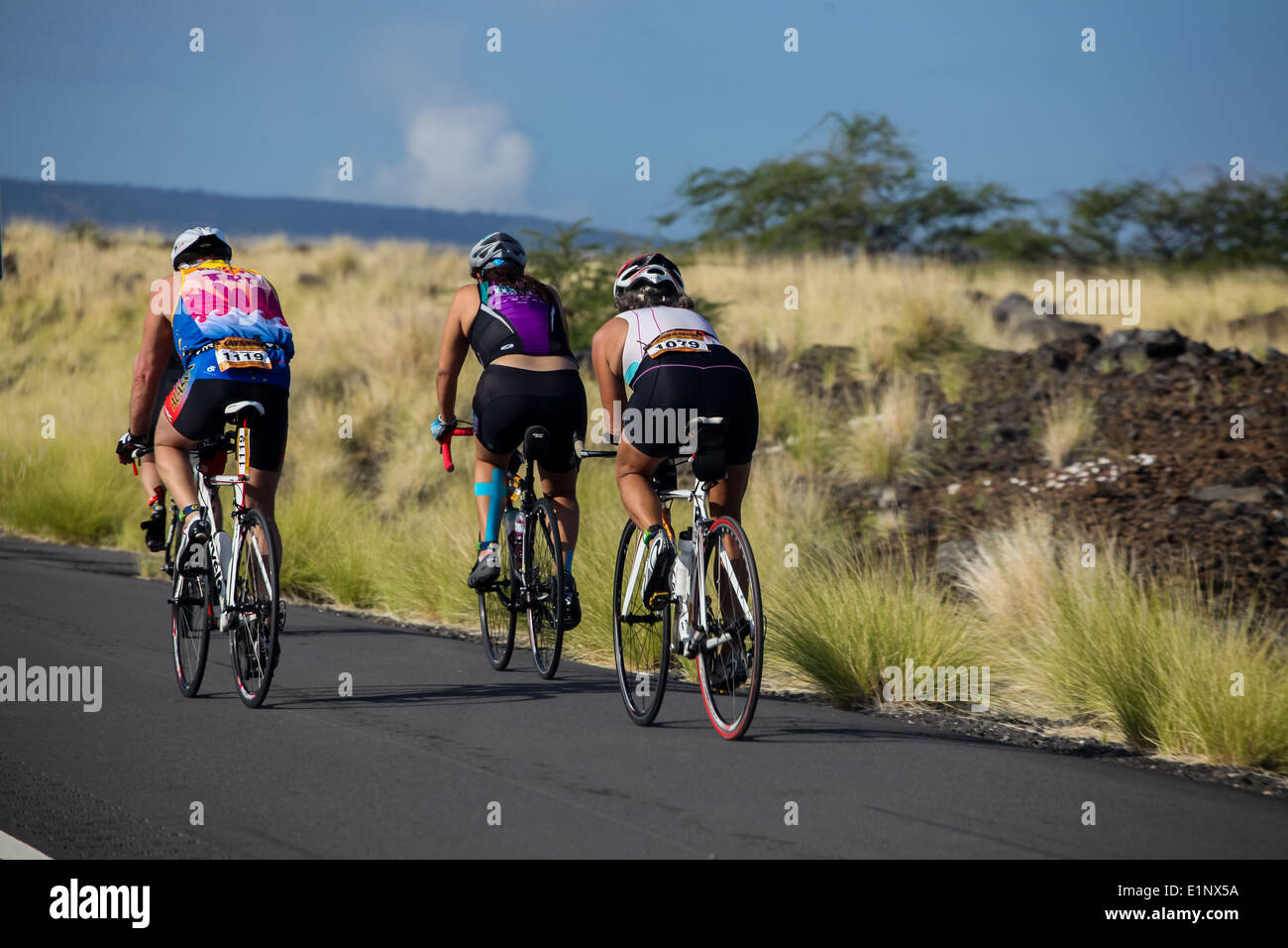 Unidentified cyclers on the Lavaman Triathlon in Waikoloa, Hawaii. It is held in Olympics format: 1.5 km swimming, 40 km biking and 10 km running. Stock Photo