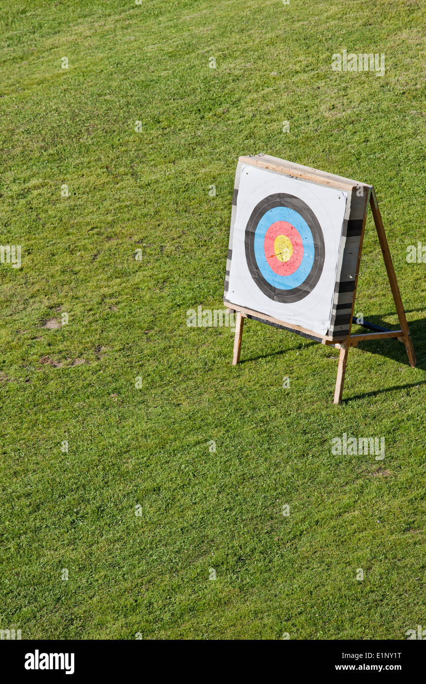 Archery round paper face field target on a stand on a green field with freshly cut grass. Stock Photo