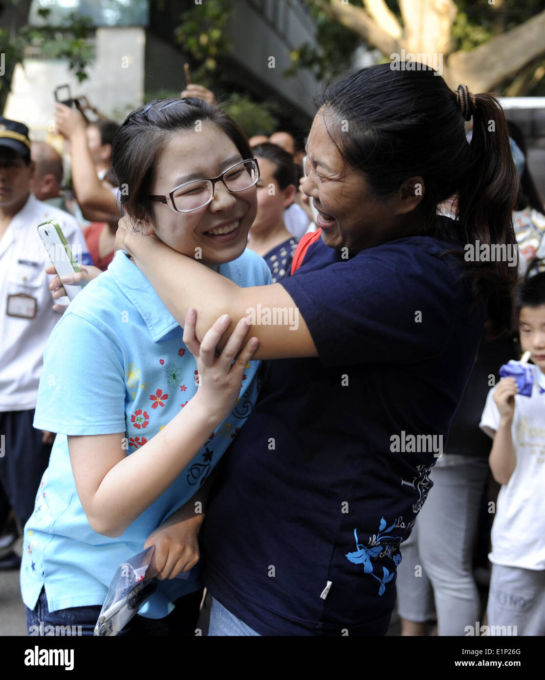 (140608) -- ZHENGZHOU, June 8, 2014 (Xinhua) -- A student embraces her parent after finishing the National College Entrance Exam (NCEE) at Zhengzhou Huimin Middle School in Zhengzhou, capital of central China's Henan Province, June 8, 2014. The 2014 National College Entrance Exam ended on Sunday in most part of China (in a few provinces the NCEE will last for one more day). Statistics show that the NCEE has 9.39 million candidates in 2014, which is 270,000, or 3 percent, more than the 2013 figure. In all, there will be 6.98 million new enrollments at China's higher education institutions this  Stock Photo