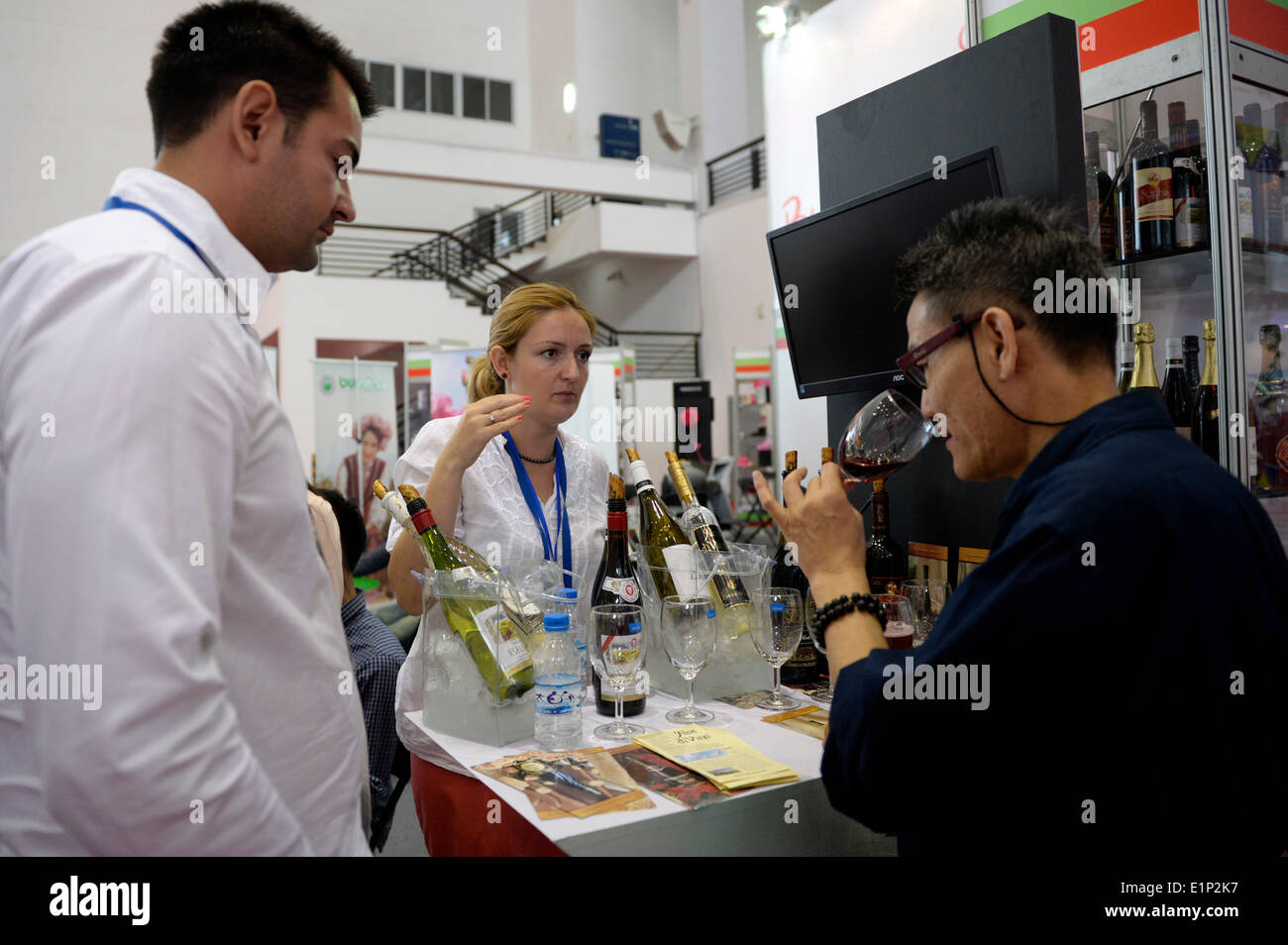 Ningbo, China's Zhejiang Province. 8th June, 2014. A visitor savours Bulgarian wine at the 2014 Central and Eastern European Countries' Products Fair (CEEC Fair) in Ningbo, east China's Zhejiang Province, June 8, 2014. Opening Sunday in Ningbo, the 2014 CEEC Fair attracted 180 exhibitors from 16 Central and Eastern European countries. The fair is part of the 2014 China Ningbo-CEEC Economic and Cultural Exchange Week. © Ju Huanzong/Xinhua/Alamy Live News Stock Photo