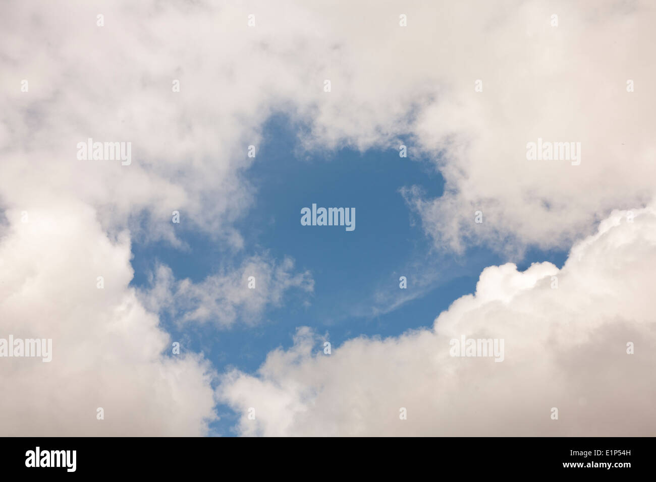 Cumulus Clouds with a patch of blue sky Stock Photo