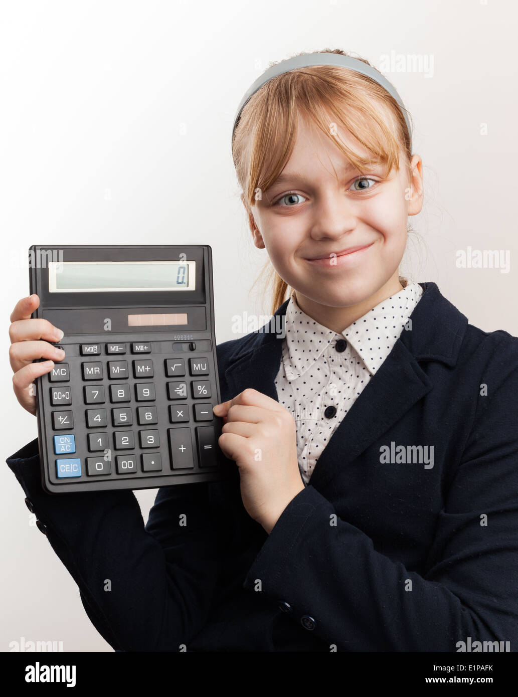 Little blond smiling schoolgirl with calculator above white Stock Photo