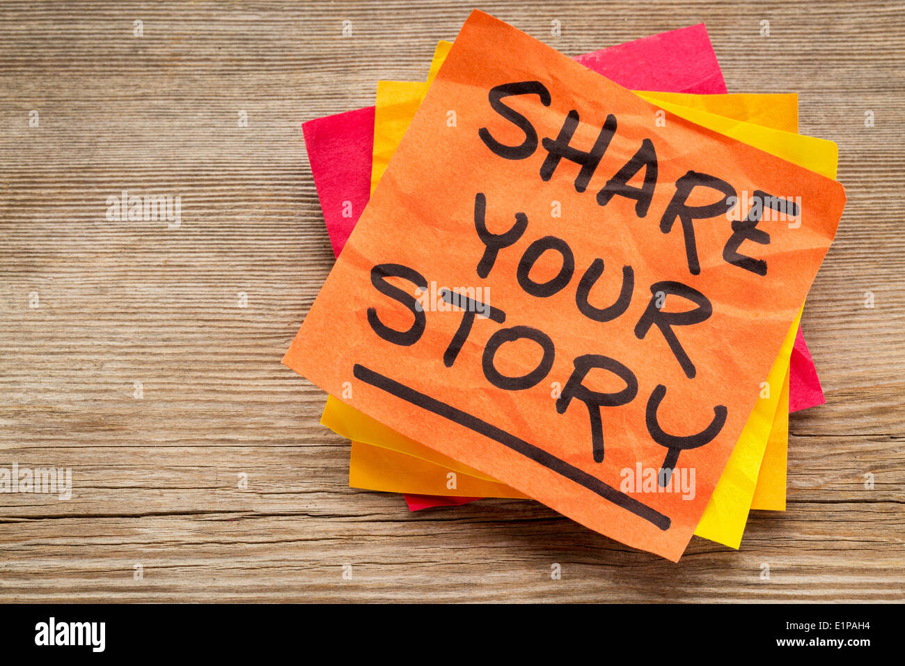 share your story suggestion on a sticky note against grained wood Stock Photo