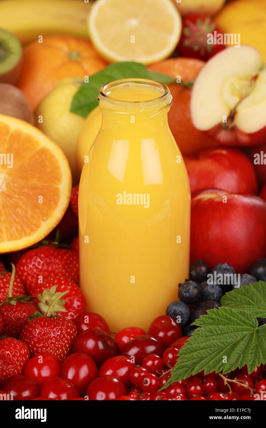 Orange juice in a bottle surrounded by fresh fruits Stock Photo