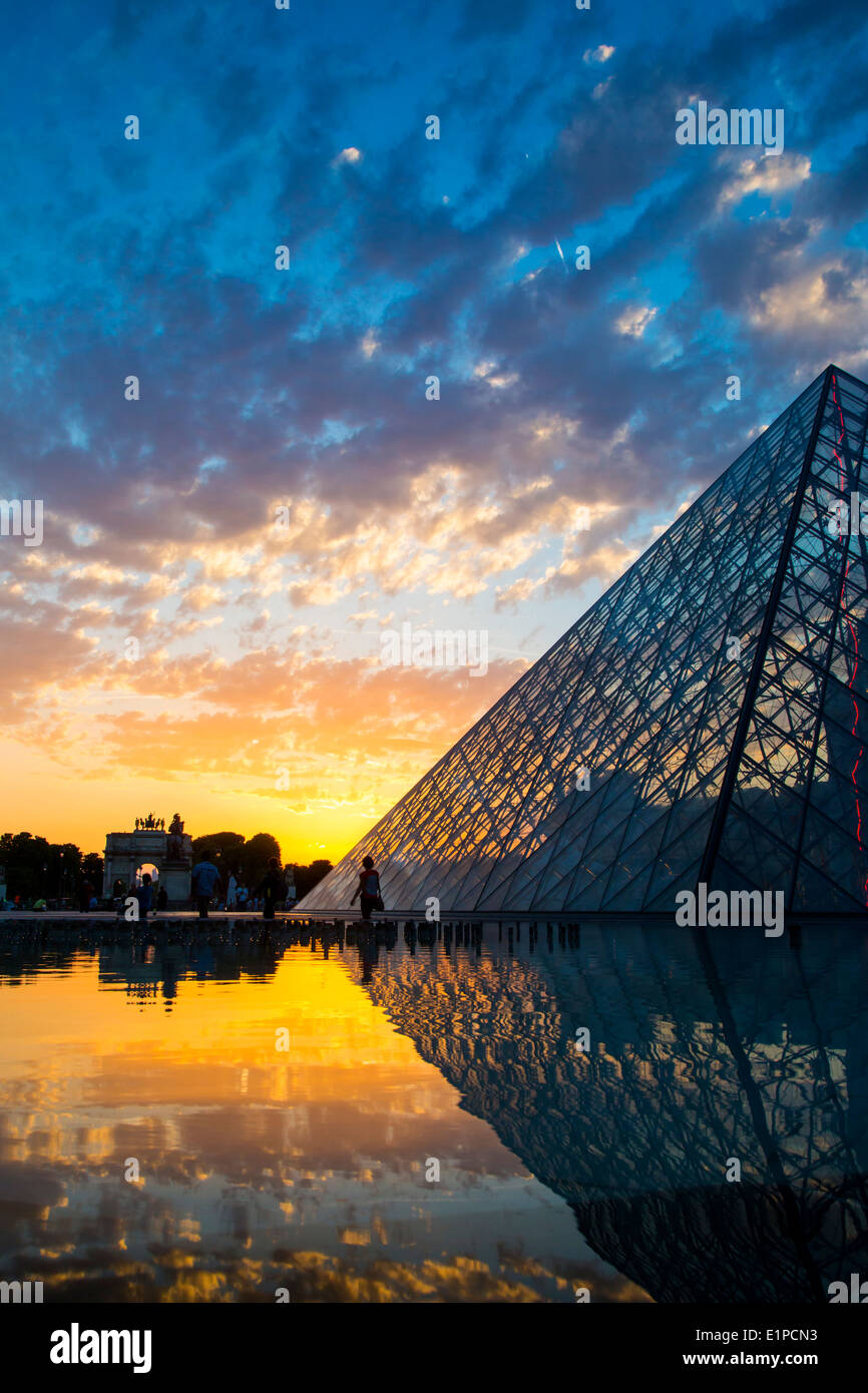 Setting sunlight and reflections the glass pyramid of Musee du Louvre and Arc de Triomphe du Carrousel, Paris France Stock Photo