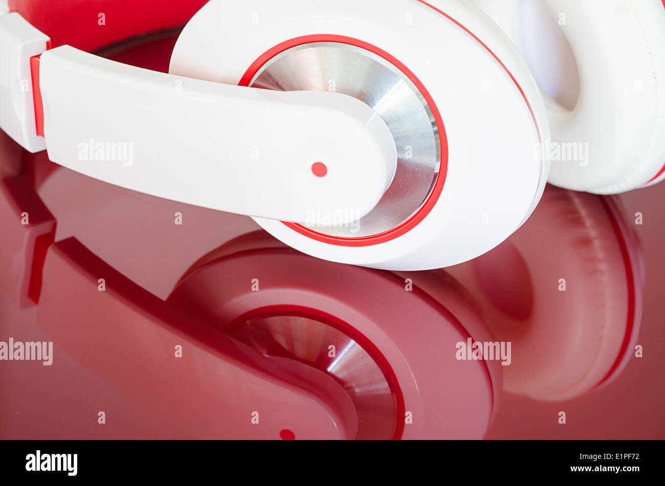 White red headphones on vinous clear polished mirrored surface Stock Photo