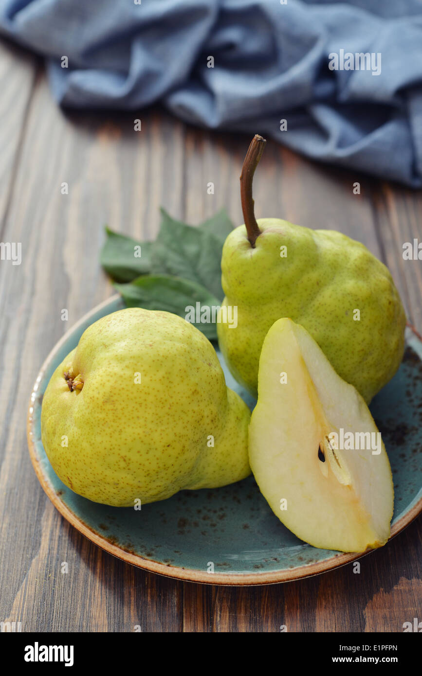 Fresh pears on plate over wooden background closeup Stock Photo