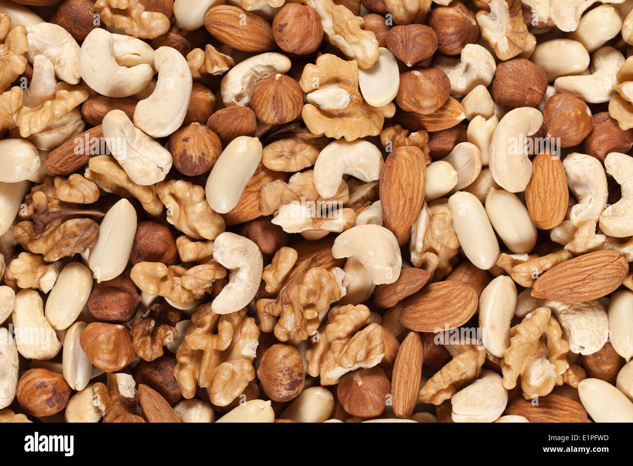 Collection of nuts such as peanuts, walnuts, almonds, hazelnuts, Brazil nuts and Macadamias forming a background Stock Photo