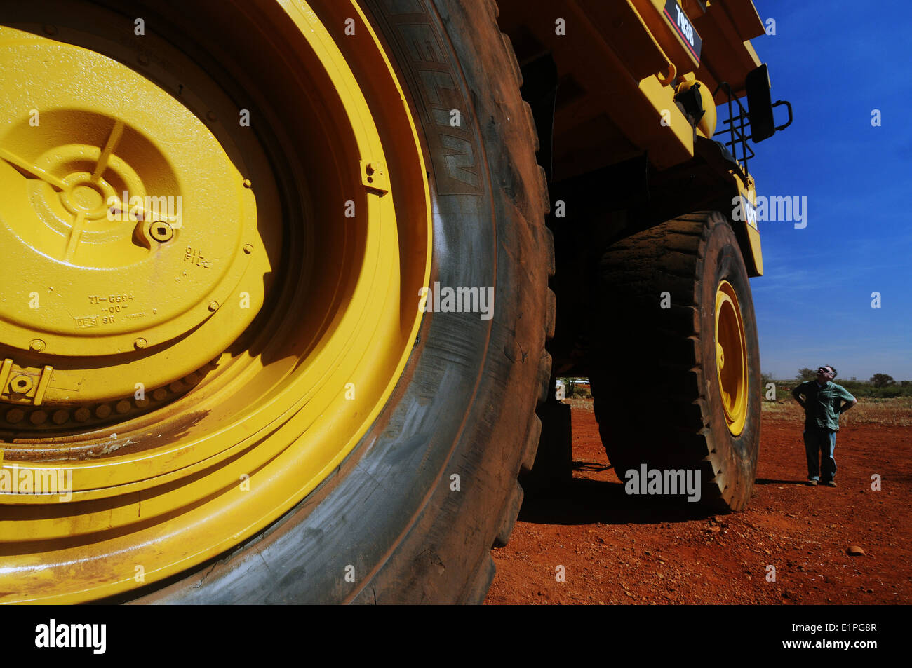 Man looking at enormous haulpak mining truck, Pilbara region, Western Australia. No MR or PR Stock Photo