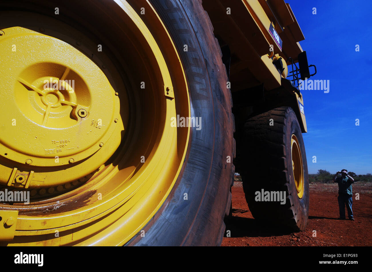 Man photographing enormous haulpak mining truck, Pilbara region, Western Australia. No MR or PR Stock Photo
