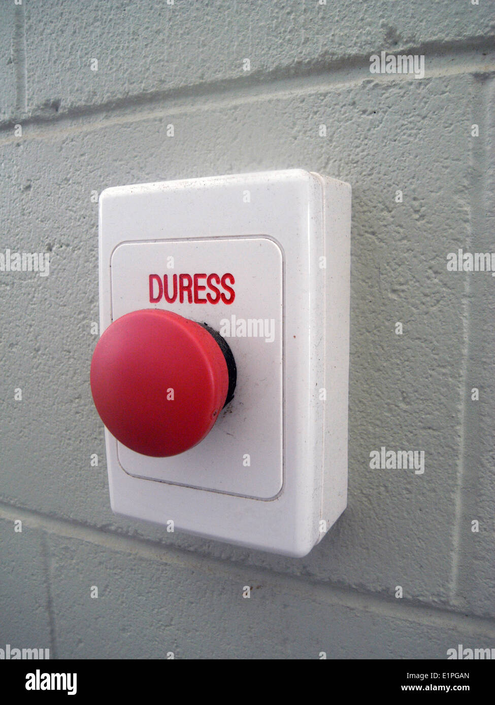 Red duress button on wall Stock Photo
