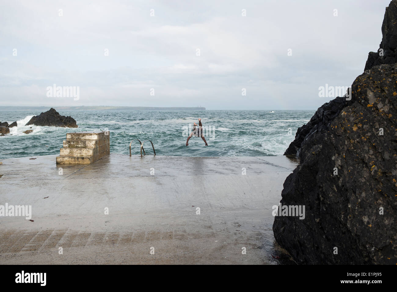 Man dives form the swimming platform, Newtown Cove, Ireland Stock Photo