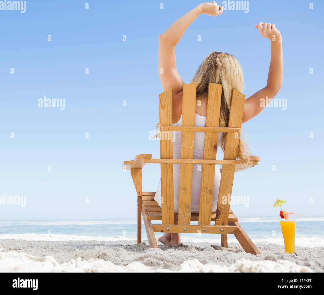 Pretty blonde sitting in deck chair with a cocktail Stock Photo