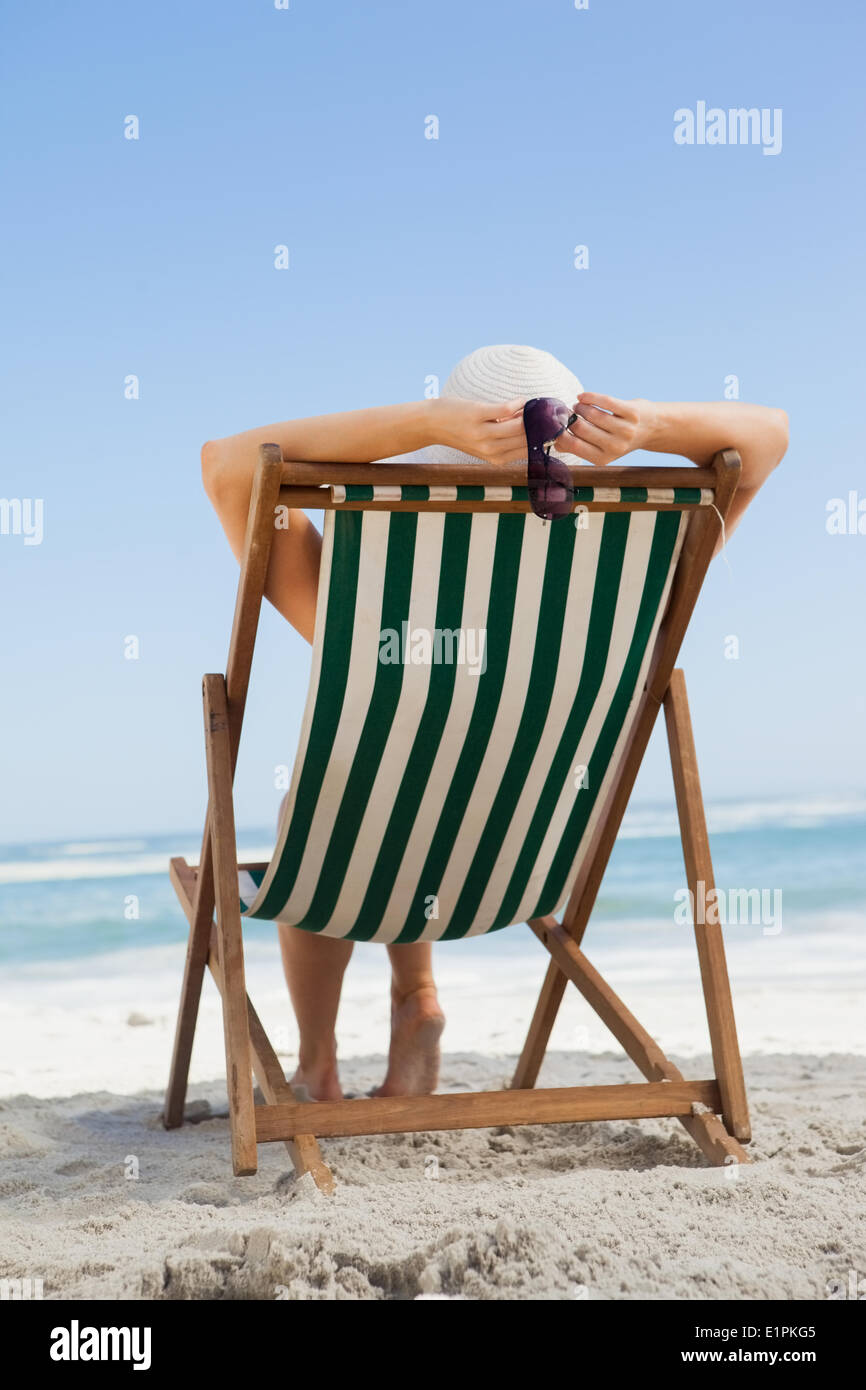 Woman sitting in deck chair at the beach Stock Photo
