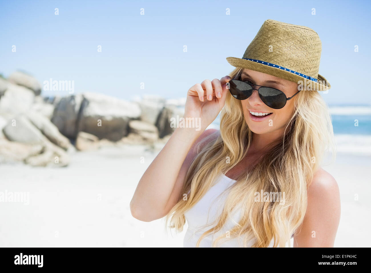 Stylish blonde smiling at camera on the beach Stock Photo - Alamy