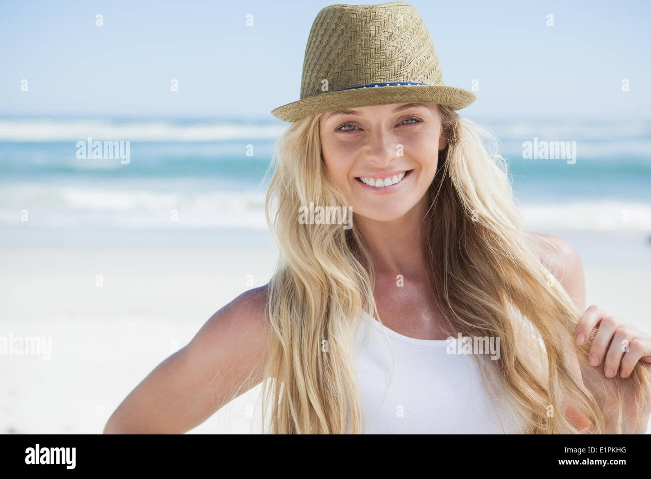 Stylish blonde smiling at camera on the beach Stock Photo - Alamy