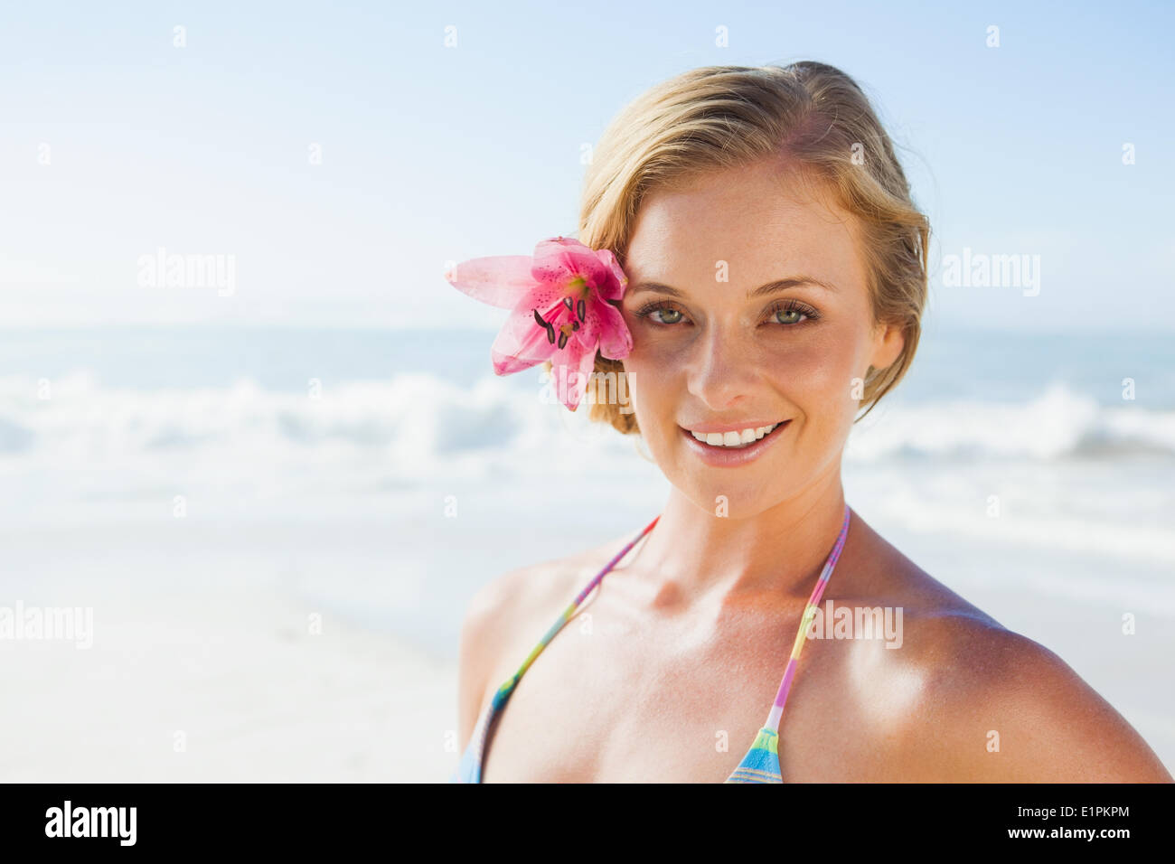 Gorgeous blonde in bikini smiling at camera on the beach Stock Photo