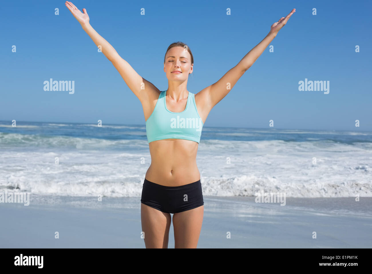 full length of fit woman in shorts and sports bra exercising on beach Stock  Photo - Alamy