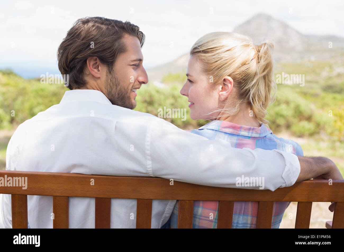 Cute couple sitting on bench together Stock Photo