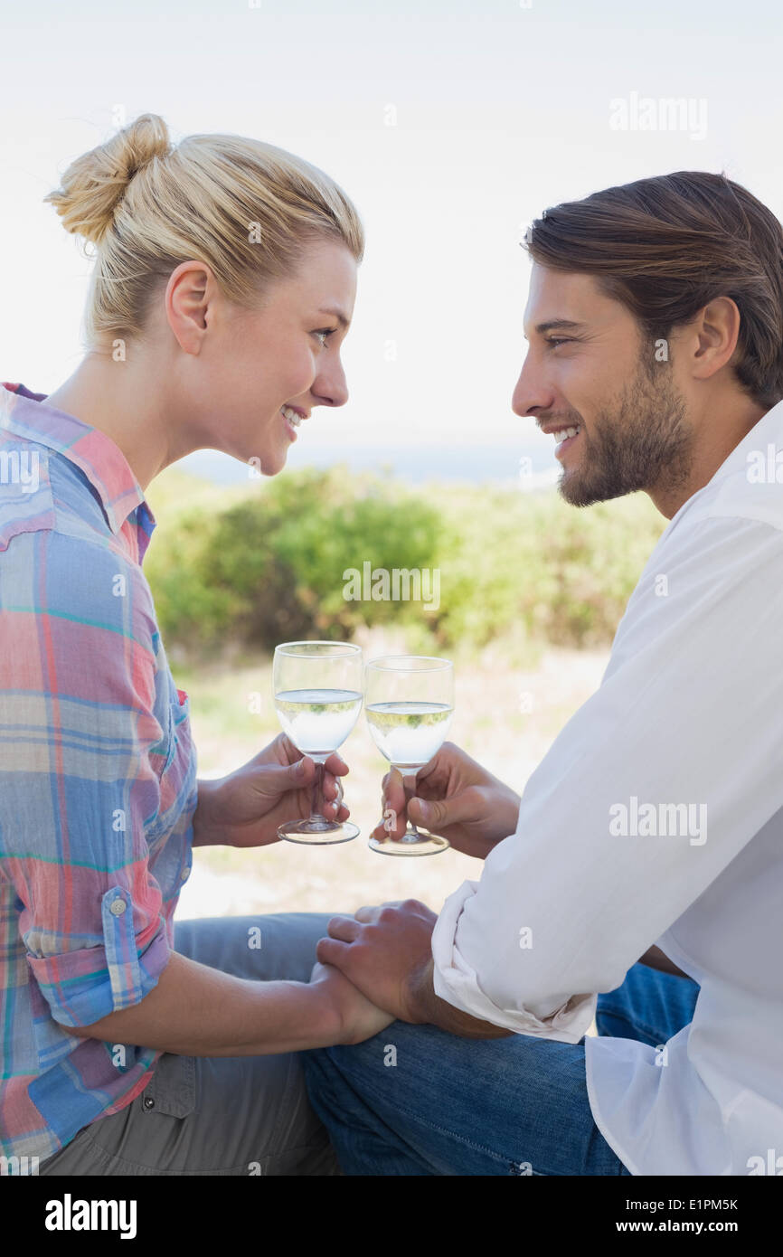 Happy young couple sitting in the garden enjoying wine together Stock Photo