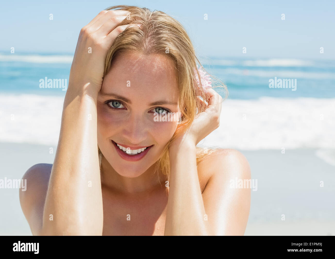 Beautiful blonde smiling at camera on the beach Stock Photo - Alamy