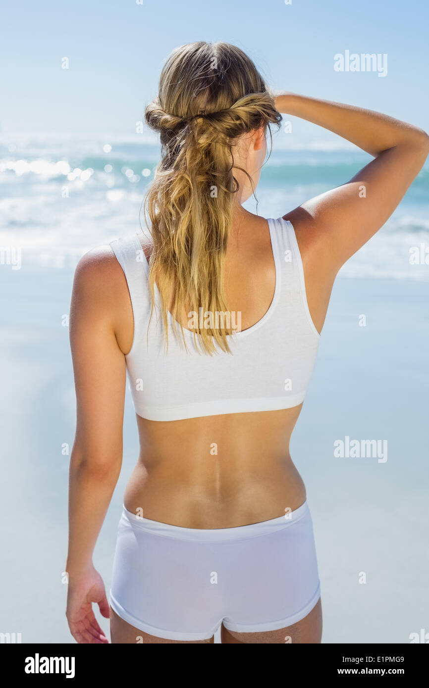 Gorgeous blonde standing by the sea looking out Stock Photo